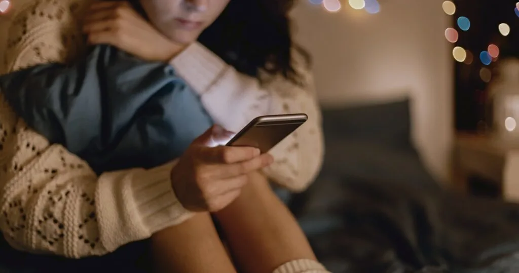 Girl in bed using phone