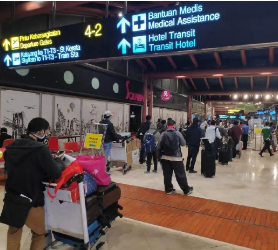 Passengers wait in line at jakarta airport using social distancing