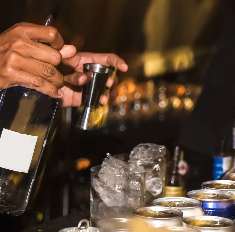 Close Up of hands of Indonesian bartender serving local Bali arak over ice
