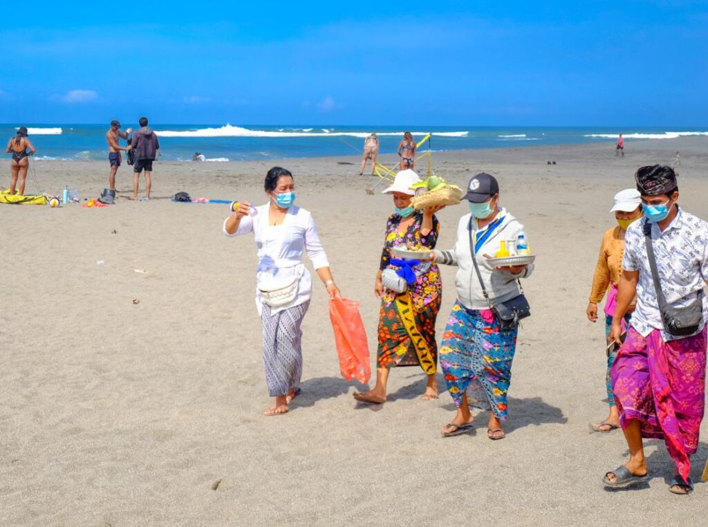 bali residents on beach wearing masks