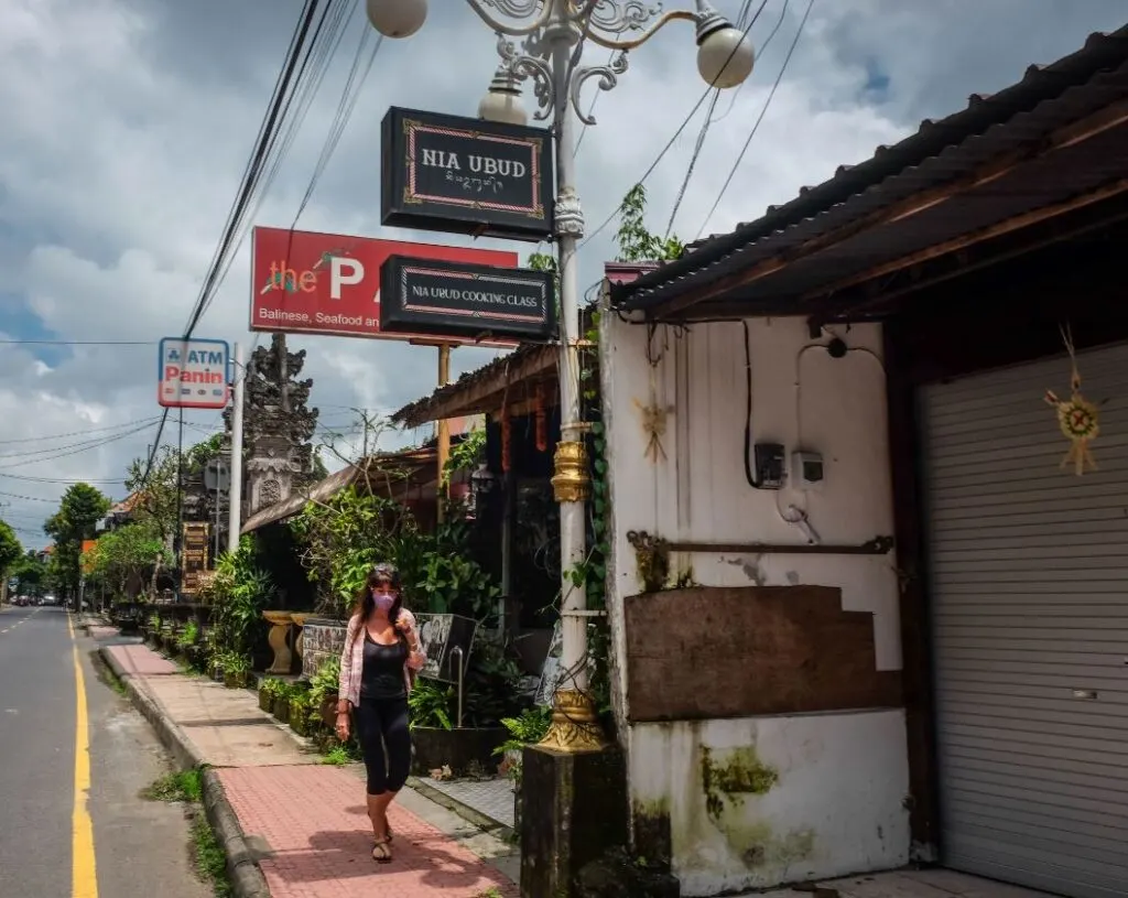 tourist in ubud walking down the street in face mask