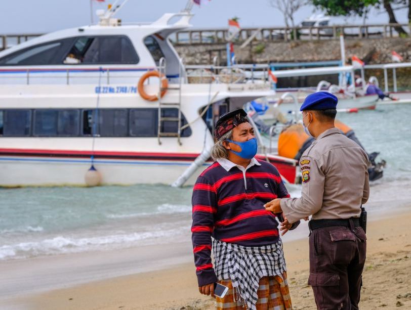 officer investigating local at beach in Bali