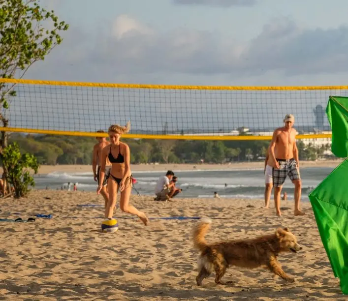 tourists playing volleyball Bali beach