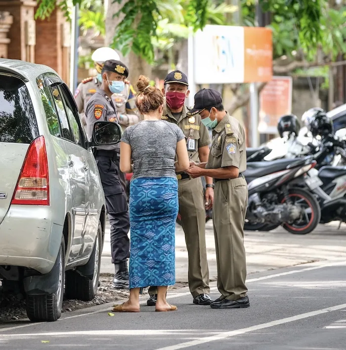 police handing out mask fine to tourist