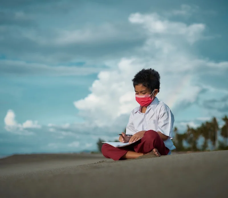 school boy studying on beach bali