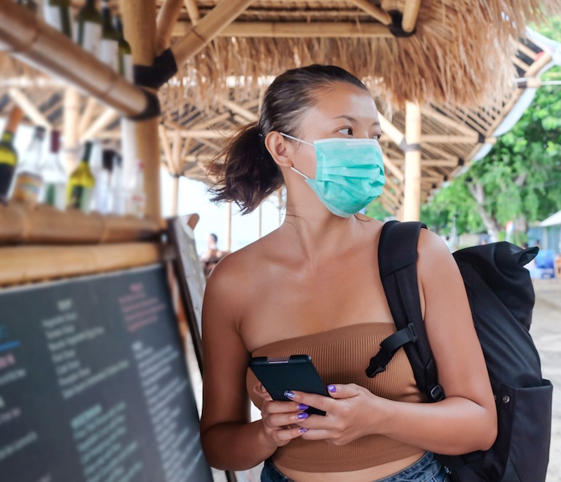 tourist_with_mask_and_phone_bali_jpg
