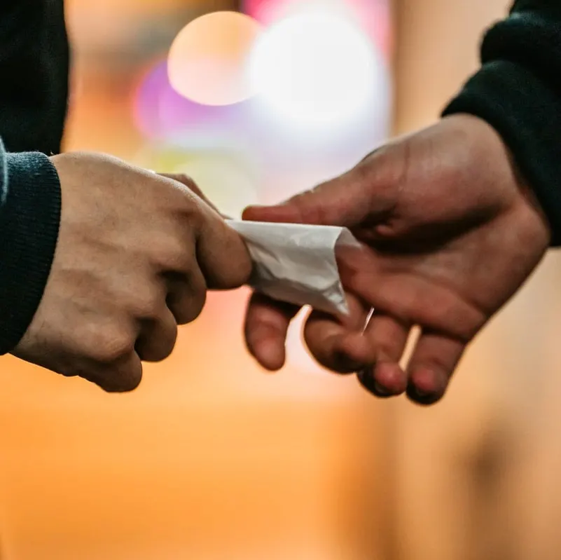 Man passing drugs on the street