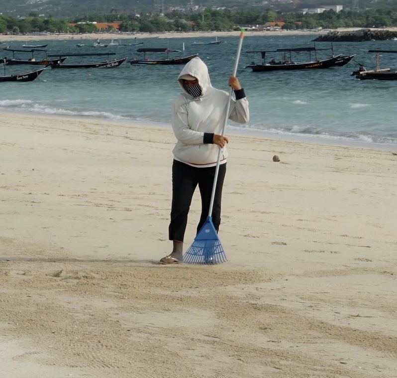 Woman cleaning Bali beach