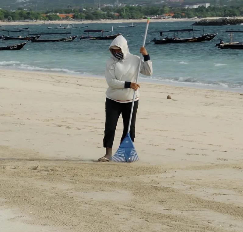 Woman cleaning Bali beach