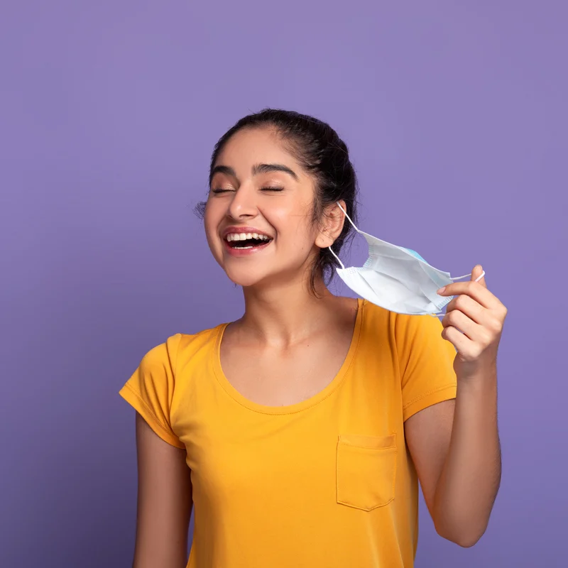 woman removing mask