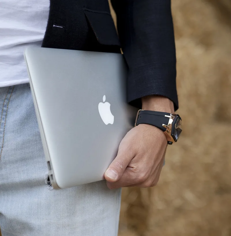 male is holding MacBook Air