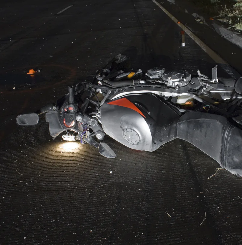 Motorcycle moped lies on the ground after crash at nighttime