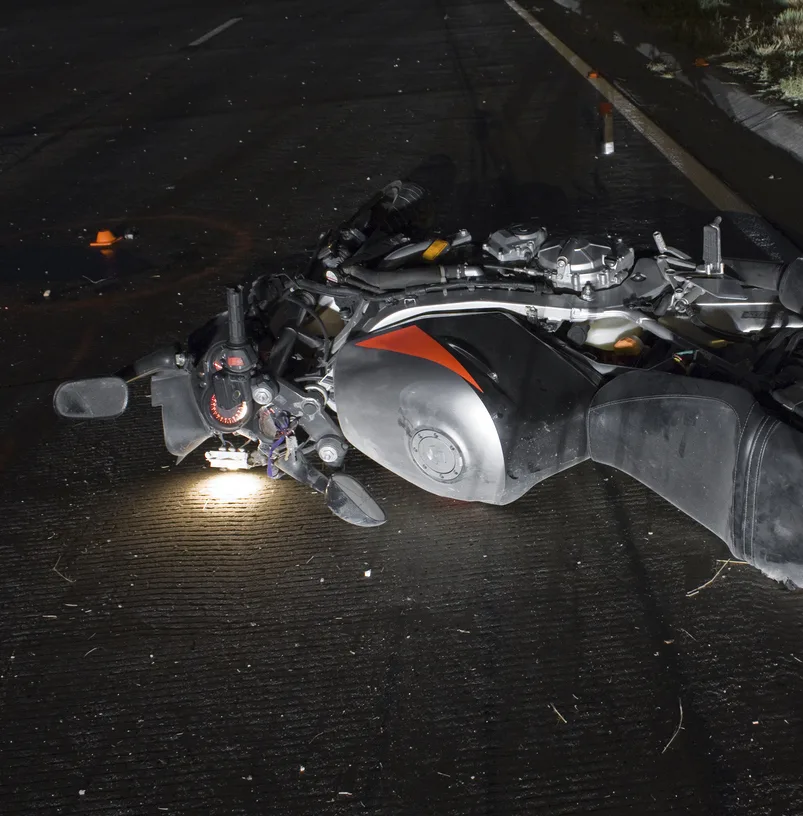 Motorcycle moped lies on the ground after a nighttime accident