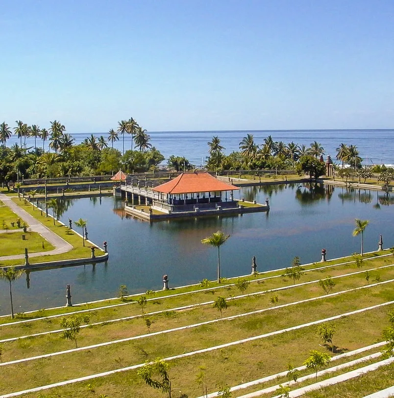 Temple in bali surrounded by water and green grass