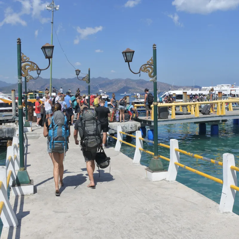 Backpackers-Walk-Along-A-Jetty-To-A-Bali-Fast-Boat