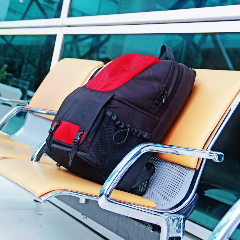 Black-and-Red-Backpack-On-Airport-Chairs