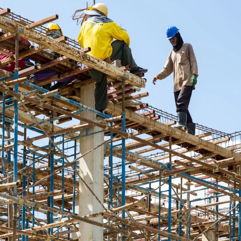 Construction-Workers-Walk-Across-Scaffoling