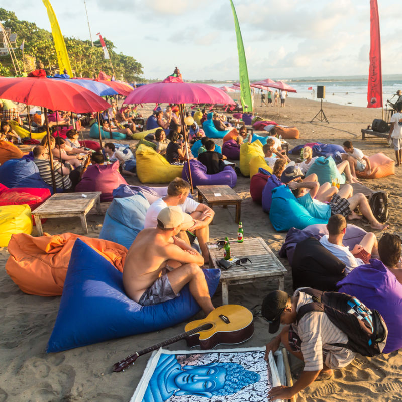 Tourist-Beach-In-Bali-Busy-With-Tourists-Sitting-On-Beanbags