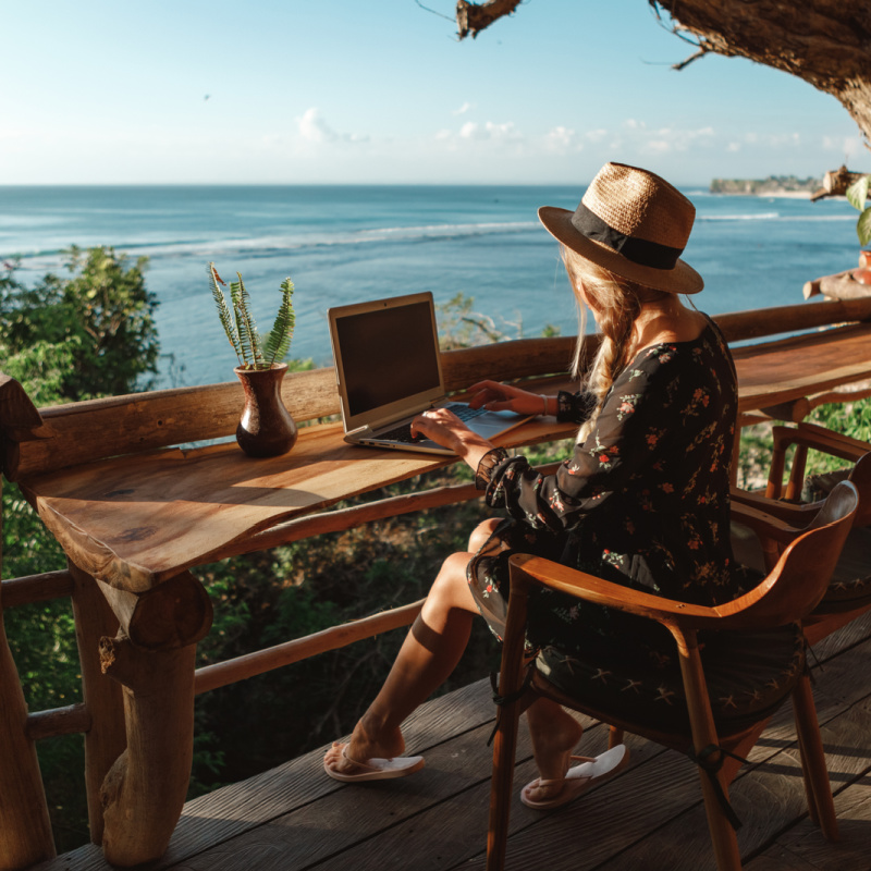Woman-At-A-Bali-Beach-Cafe-Works-Online-On-Her-Laptop