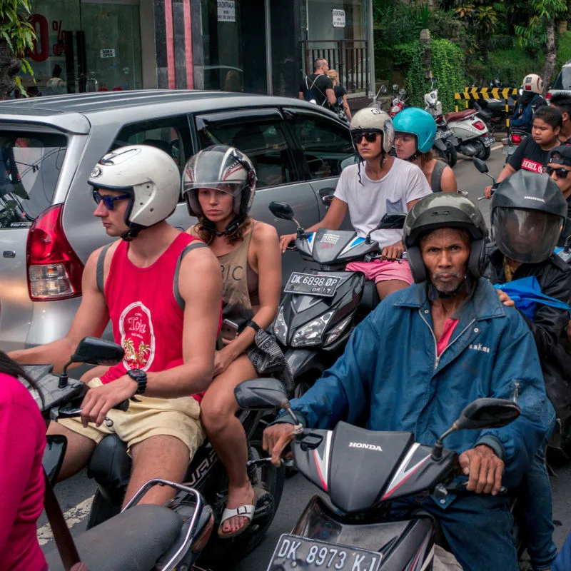 Balinese-Drivers-And-Tourists-On-Mopeds-In-Bali-Sit-In-Traffic