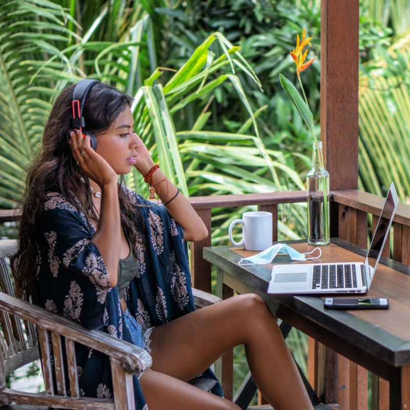 Digital-Nomad-Remote-Worker-Sits-At-Her-Laptop-In-A-Bali-Cafe-Surrounded-By-Tropical-Jungle