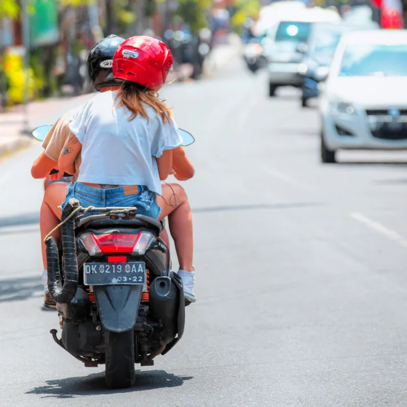 Young-Tourist-Couple-In-Bali-Drive-A-Moped-