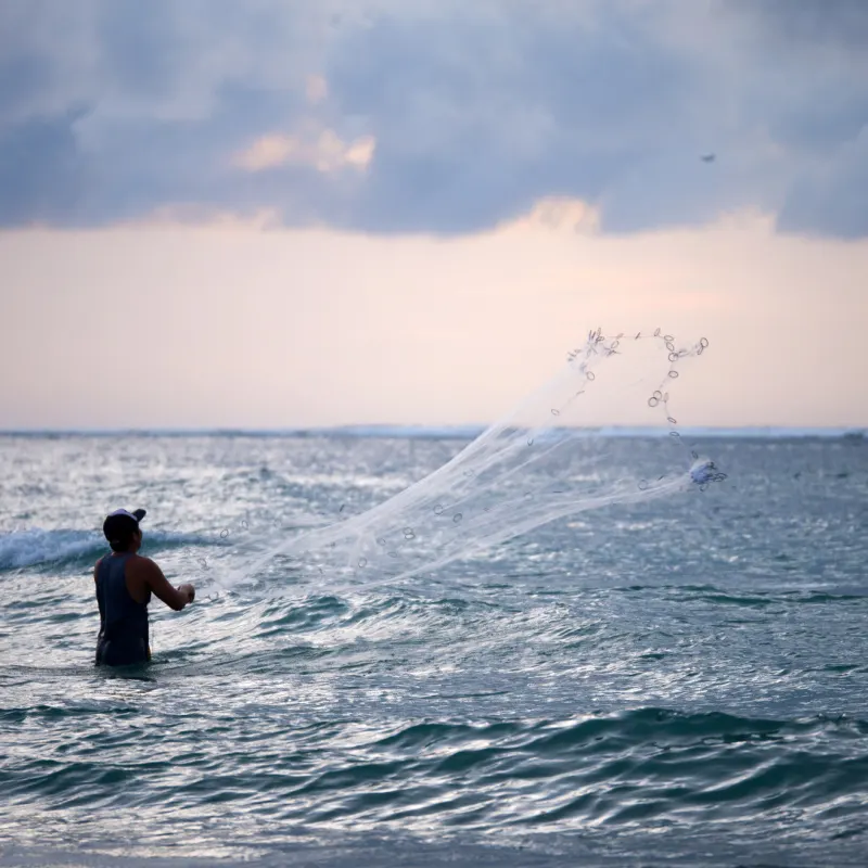 Bali-Fisherman-Casts-Fishing-Net-Into.-Sea