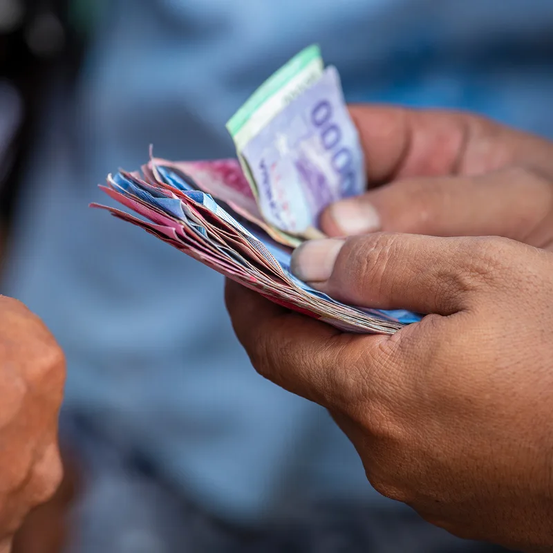 Close-Up-Of-Indonesian-IDR-Rupiah-Money-Cash-In-Persons-Hand