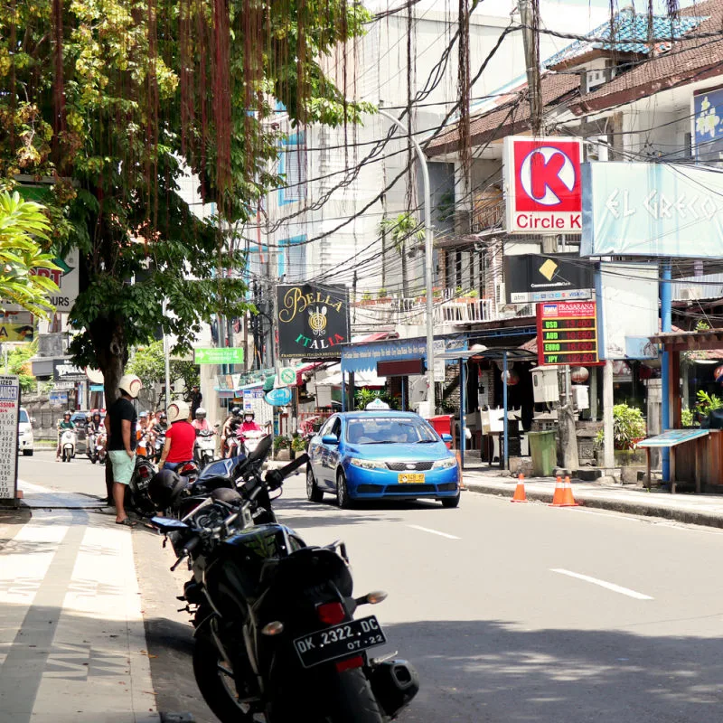 Street-In-Central-Kuta-With-Mopeds-and-Blue-Bali-taxi