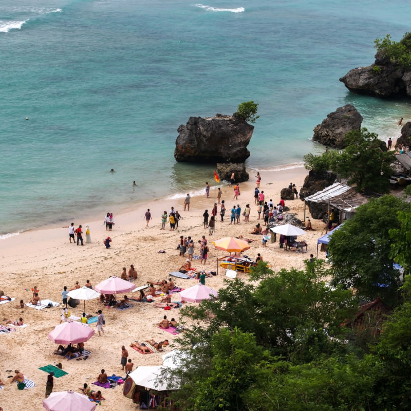 Tourists relaxing on busy Padangbai Beach in Bali