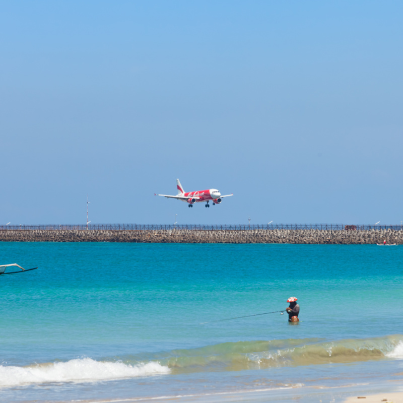 Airplane Comes Into Land Over Bali Sea At Bali Airport Runway