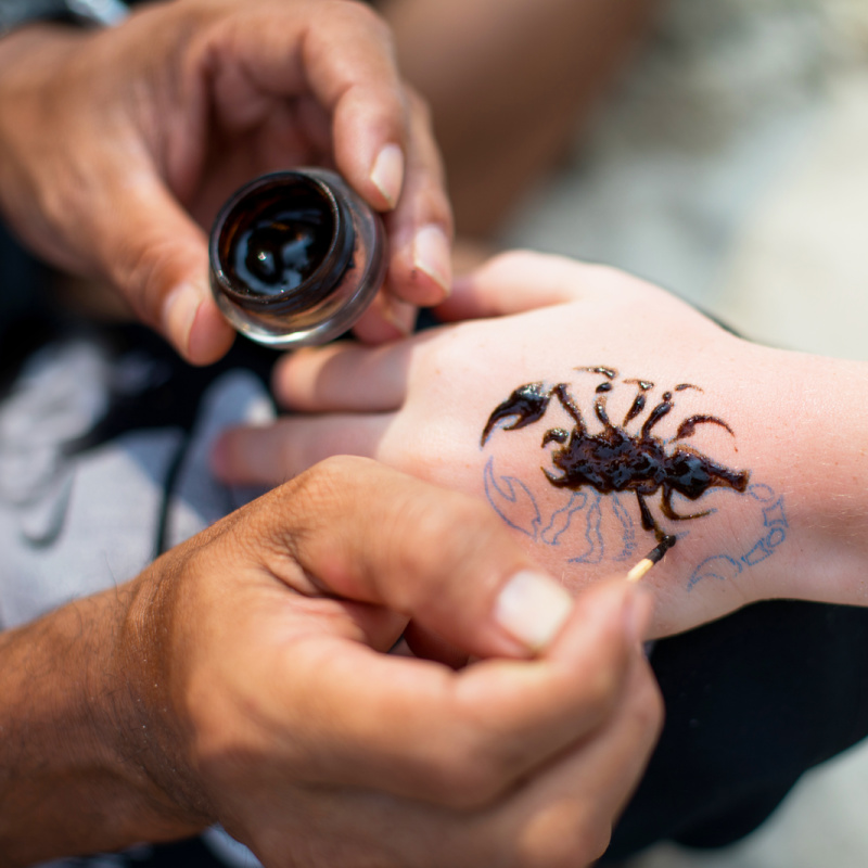 Close-Up-Of-Child-Getting-Black-Henna-Tattoo-Of-a-Scorpion