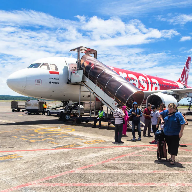 Passengers disembark from an AirAsia flight at Denpasar Airport in Bali