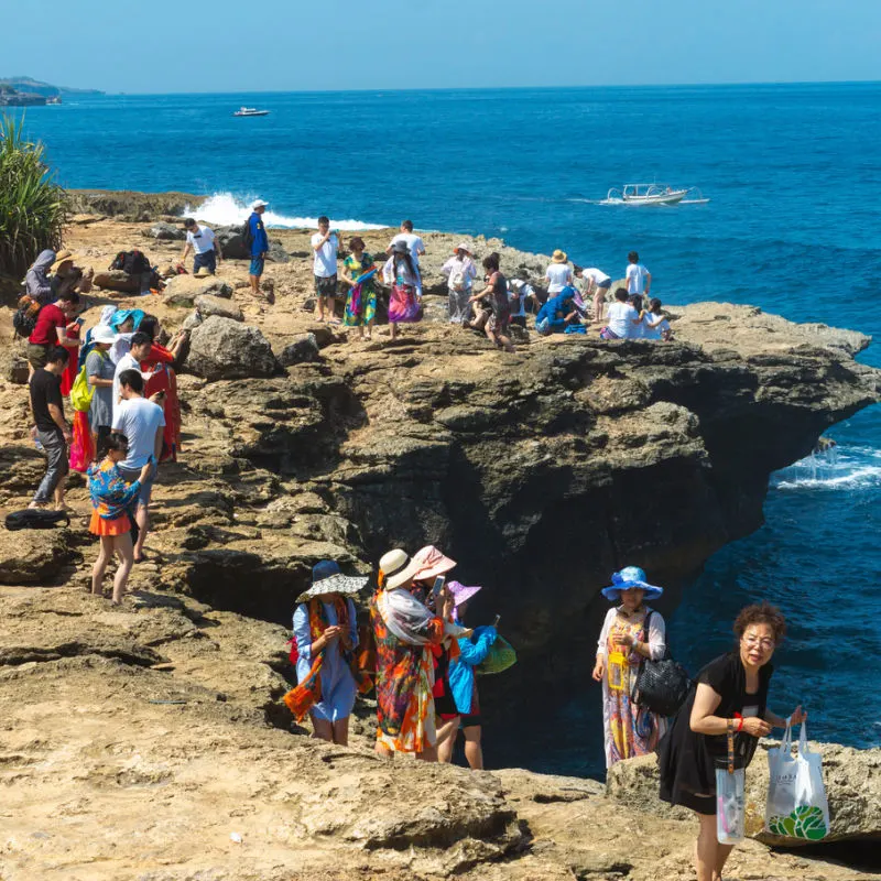 Chinese Touirsts Explore Cliffs Of Nusa Lembongan Bali