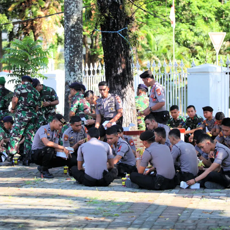 Indonesia Security Forces Police and Army TNI Sit To Take Rest Lunch Break Under A Tree