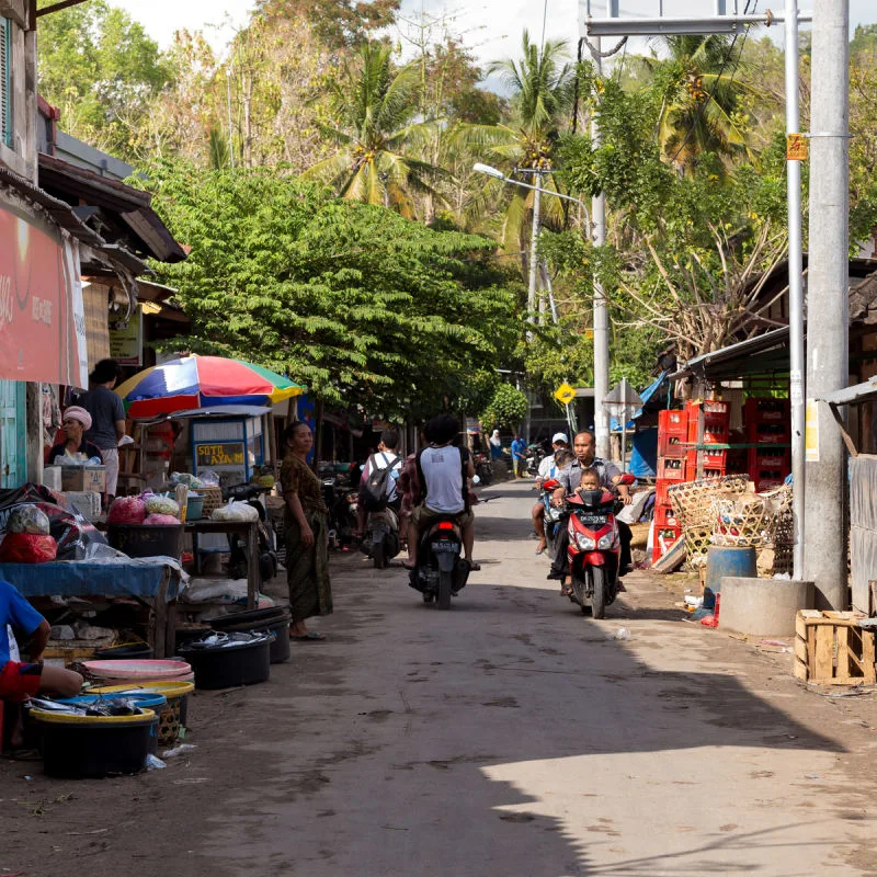 Mopeds Drive Down Village Road In Nusa Penida Bali