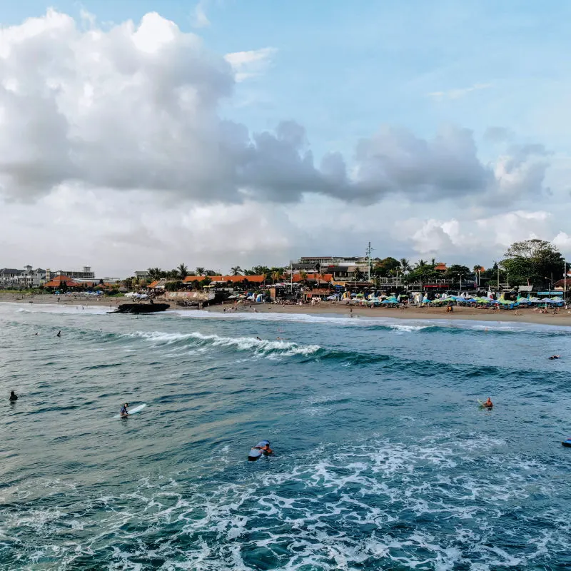 Surfers-On-The-Ocean-Look-Back-At-Canggu-beach-In-Bali