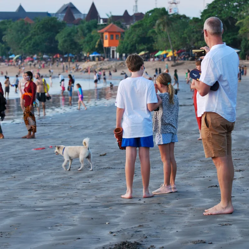Tourists Stand On Busy Kuta Beach In Bali