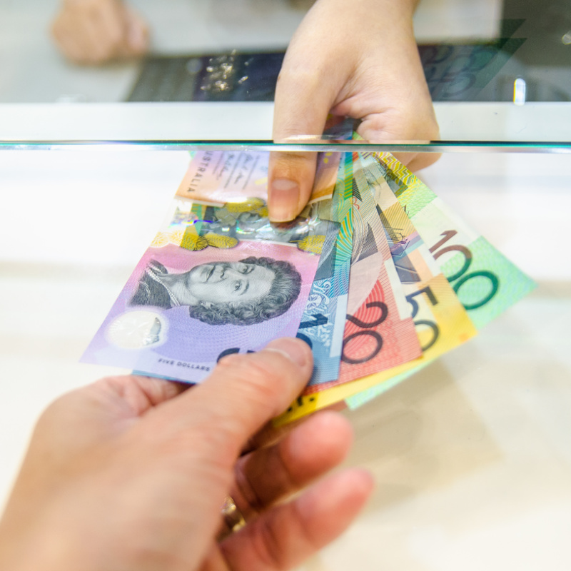 AUD Australian Dollar Cash Handed Over At Exchange Counter.