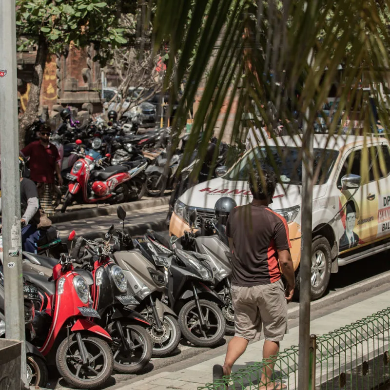 Cars and Moped Parked AtA The Side Of the Road In Bali Near Kuta