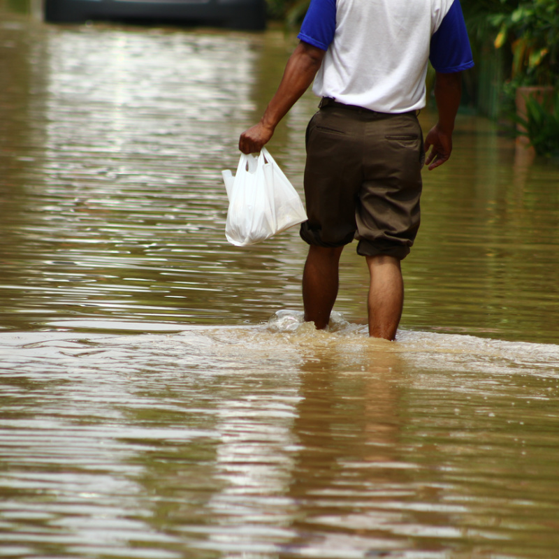 Man Walks Knee Deep In Flood Water After Bad Weather In Bali.