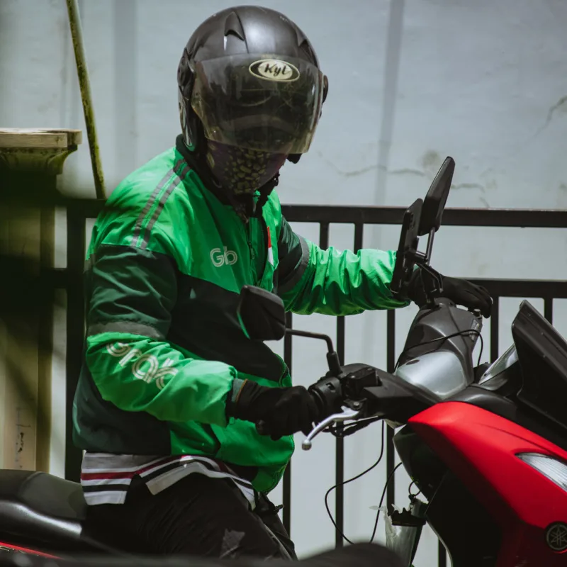 Moped-Taxi-Driver-Wears-Helmet-And-Green-Jacket-In-Bali