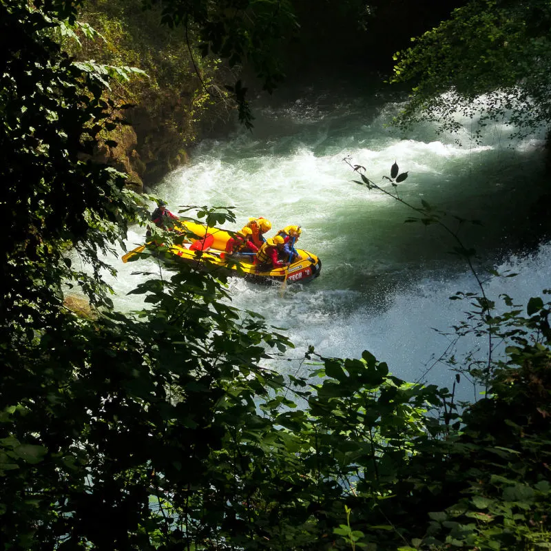 Rafters Move Into River Rapids In Jungle Forest Area Of Bali.