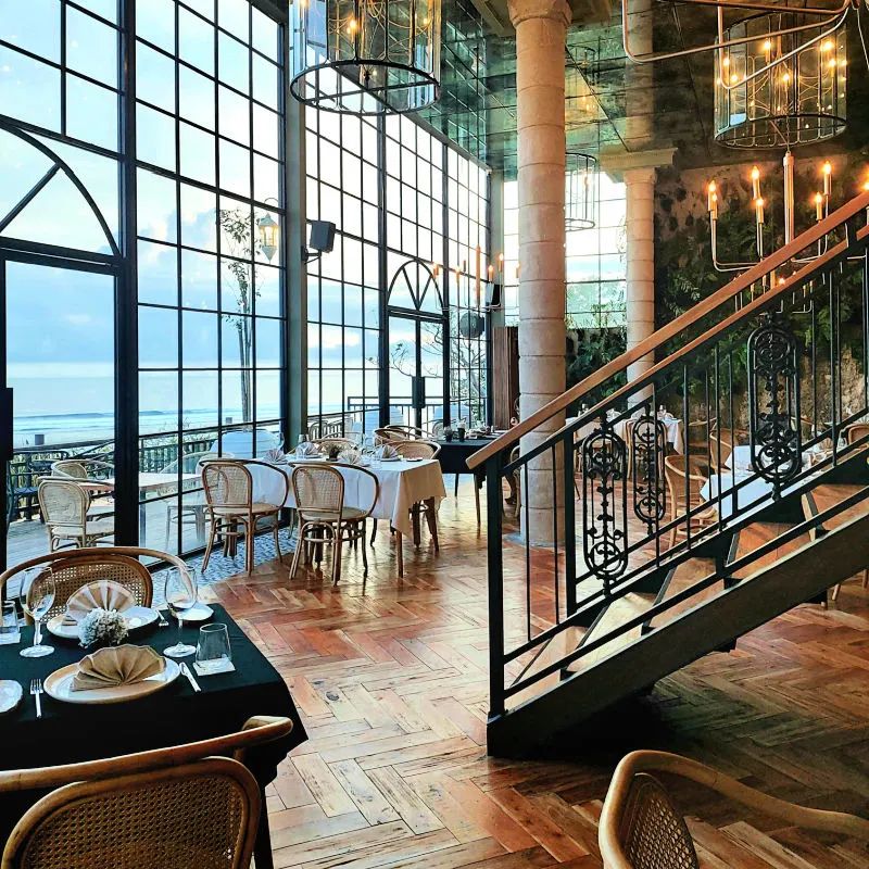 Staircase and Large Window in Dining Room at Cliff at Canna Bali.