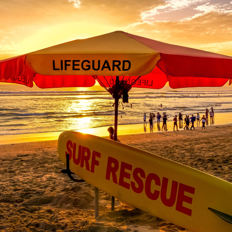 Surf Rescue And Lifeguard Point Under Umbrella On Bali Beach At Sunset