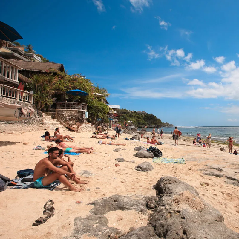 Tourists Relax On Beach Near Uluwatu In Southern Bali.jpg