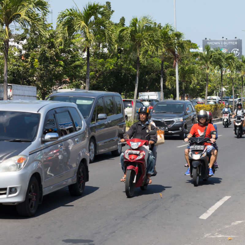 Traffic Drives Along Jalan Pantai Kuta Sunset Road In Bali