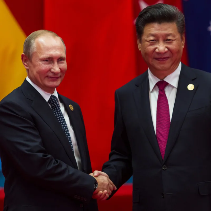 Vladimir Putin and Xi Jinping shake hands