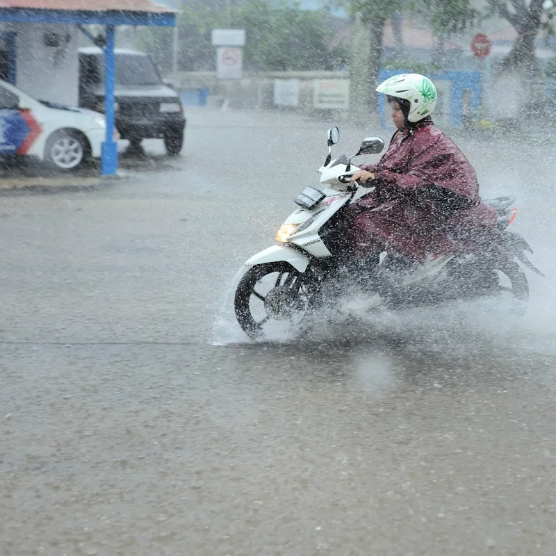Woman-In-Indonesia-Drive-Moped-Through-Rain-Storm-Floods