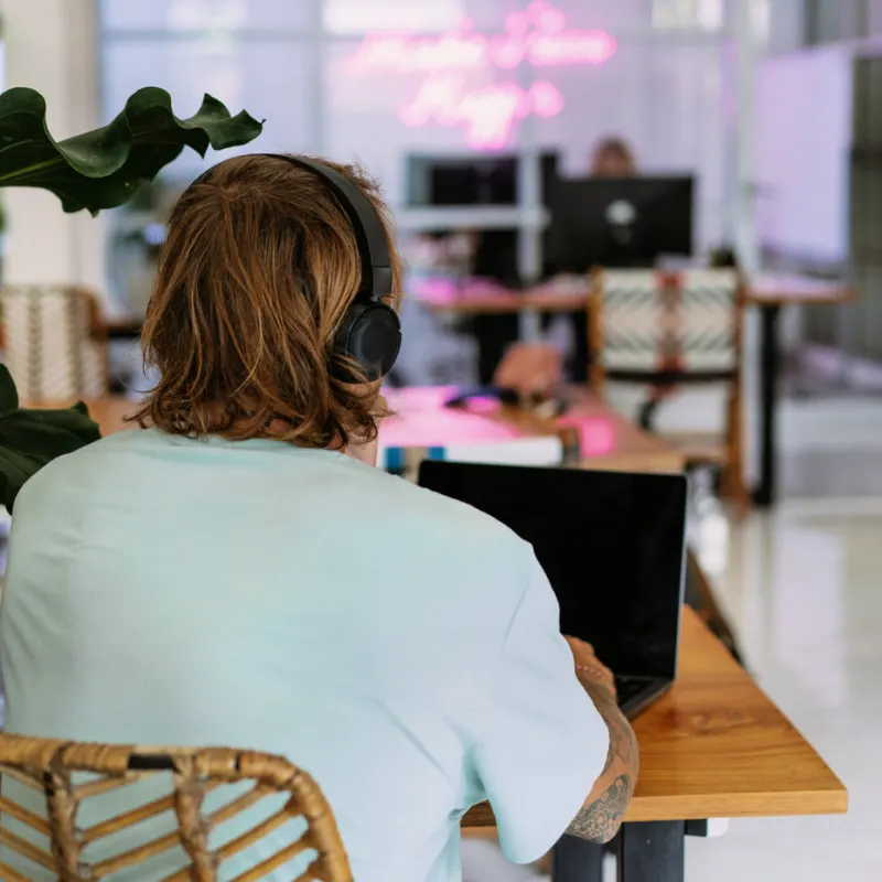 Digital Nomad In Bali Works In Coworking Office Space On His Laptop